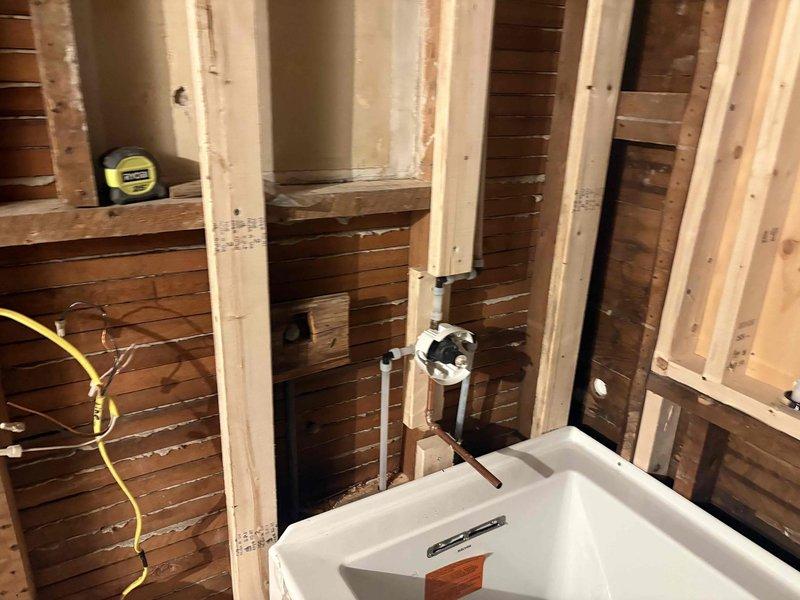 Completed rough-in plumbing installation for bathroom fixtures including toilet, vanity, and shower in accordance with quoted specifications. All supply and drain lines were properly positioned and secured within wall framing, with shower pan set and drain assembly installed to manufacturer specifications.