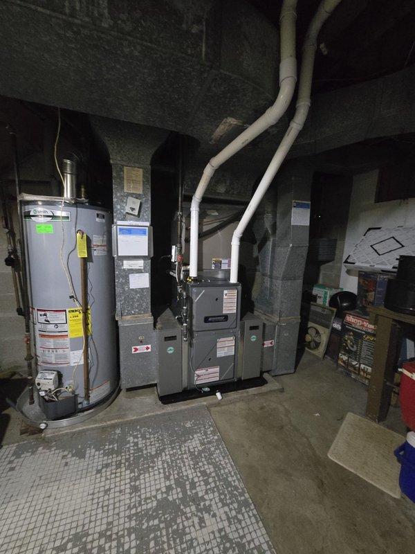 Successfully completed furnace installation in basement mechanical room. Installed new gray furnace unit with proper PVC venting system routed to exterior, positioned centrally alongside existing water heater and additional HVAC components. Verified all electrical connections, gas line hookups, and condensate drainage are properly configured and operational. System tested and confirmed functioning within manufacturer specifications.