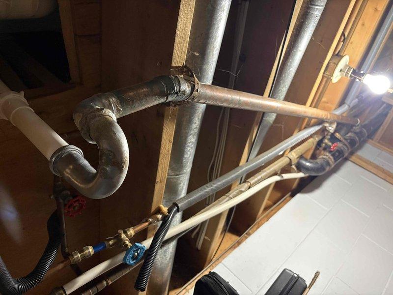 Responded to plumbing leak service call for bathtub issue. Upon inspection, accessed crawl space and identified leaking drain assembly and deteriorated trap connection beneath bathtub. Replaced corroded metal P-trap with new assembly, secured all PVC drain connections, and tested system for proper drainage and seal integrity. All connections verified leak-free and operational.