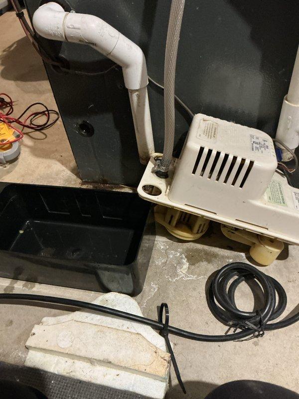 Completed annual heating and cooling maintenance on EnergiAir system including air conditioning tune-up, furnace inspection, and humidifier service under 5-year club membership plan. Inspected condensate pump system showing mineral deposits and water staining on unit and mounting platform, verified proper operation and drainage. All equipment operational with no immediate concerns noted.