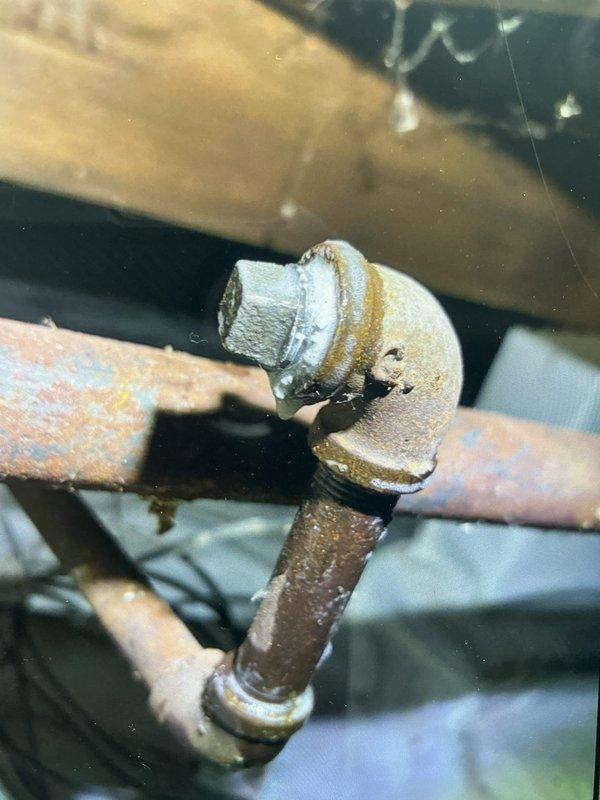 Returned to property to perform combustion analysis on heating system and contacted technical support for consultation. Documented existing plumbing infrastructure showing advanced corrosion on copper piping and brass fittings in crawl space area, with horizontal pipe section displaying significant oxidation and surface deterioration requiring attention.