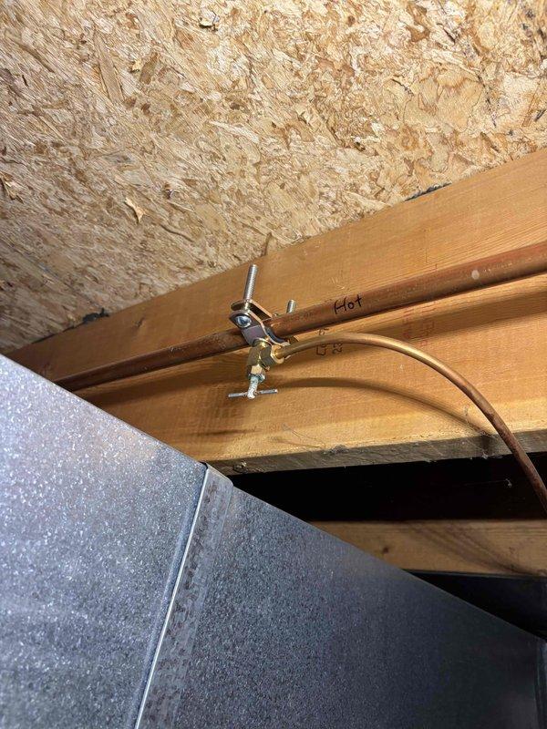 Responded to service call for humidifier with broken cover/lid that was no longer operational. Upon arrival, accessed basement mechanical systems and inspected humidifier installation mounted to ductwork. Unit age and manufacturer were unknown, possibly original to home construction. Documented existing installation configuration with copper water supply line secured to floor joists and humidifier mounted to HVAC ductwork. Assessed damage to cover assembly and provided recommendations for repair or replacement options to restore unit to working condition.