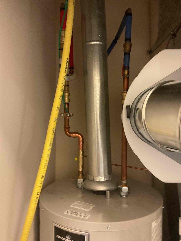 Conducted inspection and documentation of residential water heater installation. Photographed AO Smith water heater unit with Defender Safety System, including all visible components such as gas connections, plumbing lines, safety labels, and surrounding utility area. Verified proper installation of yellow flexible gas line, copper water supply piping with shut-off valves, exhaust vent system, and drainage pan placement. All equipment and connections appeared to be in functional, maintained condition per standard residential installation requirements.