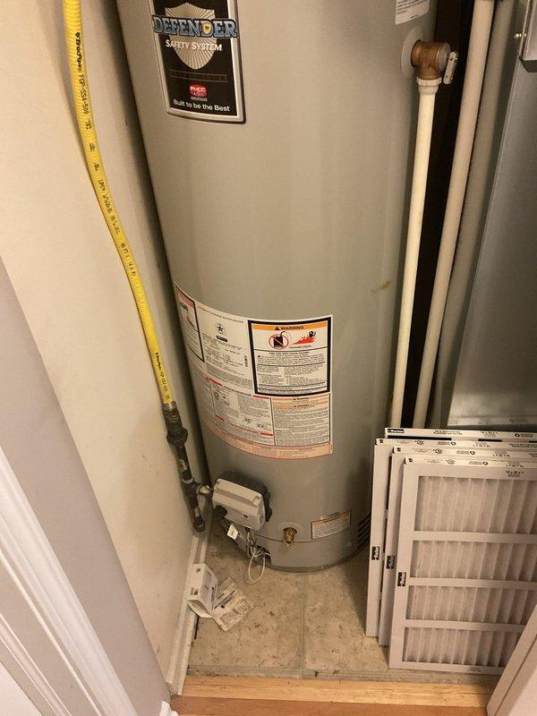 Conducted inspection and documentation of residential water heater installation. Photographed AO Smith water heater unit with Defender Safety System, including all visible components such as gas connections, plumbing lines, safety labels, and surrounding utility area. Verified proper installation of yellow flexible gas line, copper water supply piping with shut-off valves, exhaust vent system, and drainage pan placement. All equipment and connections appeared to be in functional, maintained condition per standard residential installation requirements.