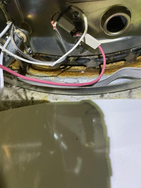 Responded to service call for water heater displaying faulty readings and low voltage issues. Upon inspection, examined internal electrical components and wiring connections at top of unit. Evaluated thermal sensors and control circuitry for proper operation and voltage readings. Assessed overall condition of aging water heater including gas burner assembly, plumbing connections, and venting system. Documented equipment condition showing signs of mineral deposits and general wear consistent with unit age. Verified all safety labels and specifications visible on exterior. Inspected copper piping, brass fittings, and gas line connections for integrity. Provided customer with diagnostic findings regarding electrical performance and recommendations for system maintenance.