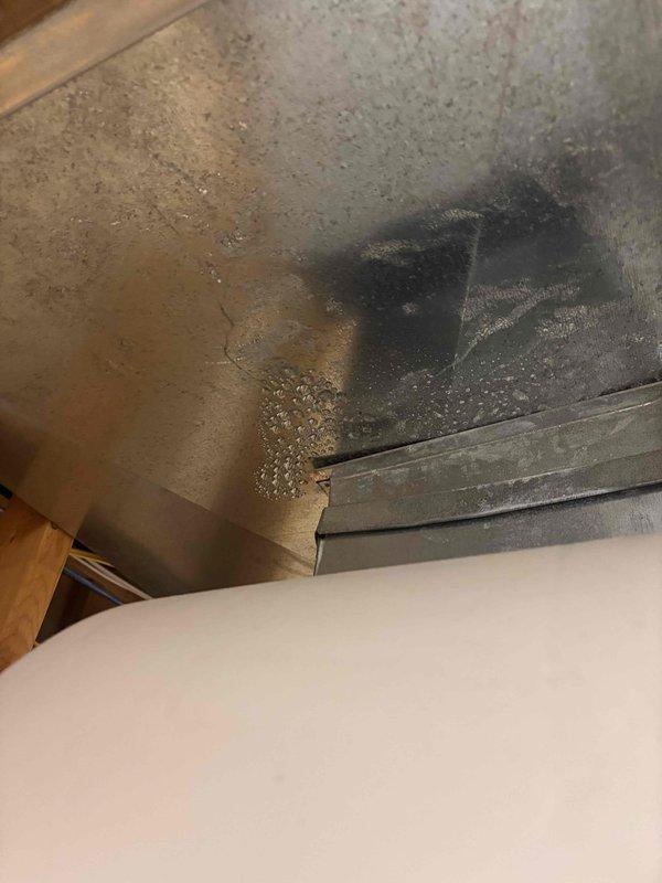 Responded to water leak complaint originating from HVAC system following recent maintenance service. Upon inspection, identified active water damage at ceiling near furnace installation with visible moisture accumulation and extensive staining. Traced leak source to condensate drainage system connected to furnace unit. 

Found condensate pump assembly with compromised tubing connections and improper drainage routing. Clear condensate tubing showed signs of disconnection or blockage, causing water to overflow and migrate through ductwork seams onto ceiling surfaces below. Rust staining on metal ductwork indicated ongoing moisture exposure from condensate system failure.

Secured all condensate line connections at pump discharge and verified proper routing to drain. Tested condensate pump operation under load to confirm proper cycling and drainage flow. Cleared any debris from condensate collection pan and verified trap integrity. Inspected all brass fittings and connection points for le