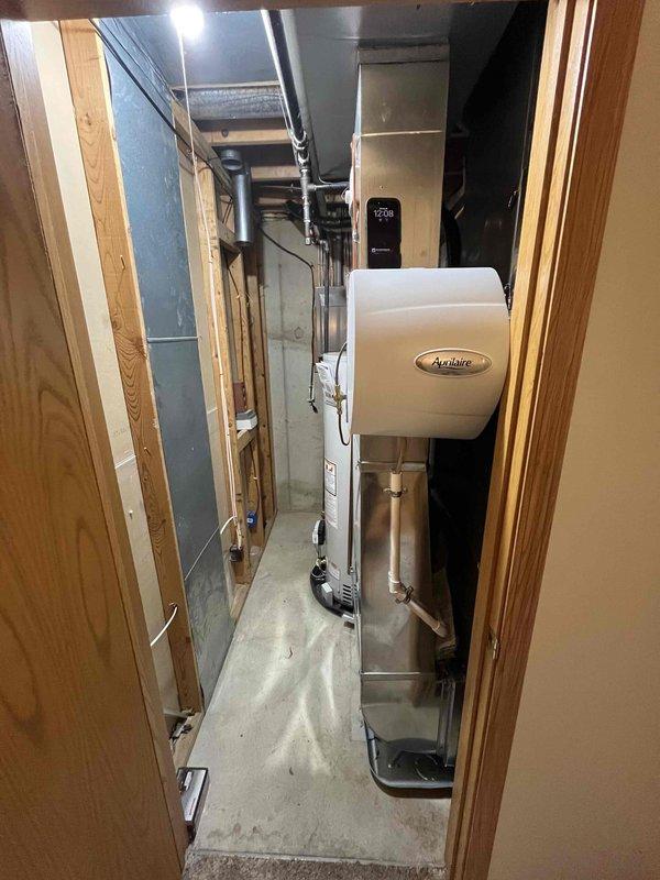 Completed full air conditioning system replacement. Removed existing outdoor condensing unit and installed new AC system with proper refrigerant charge verified and documented on equipment label. Connected brass service ports with protective caps installed on Schrader valves for future maintenance access. Interior air handler installed in basement mechanical room, integrated with existing Aprilaire whole-house humidifier and ductwork system. All refrigerant lines properly insulated and routed through cabinet. System tested for proper operation, airflow, and temperature differential across coil. All electrical connections verified and secured to manufacturer specifications.