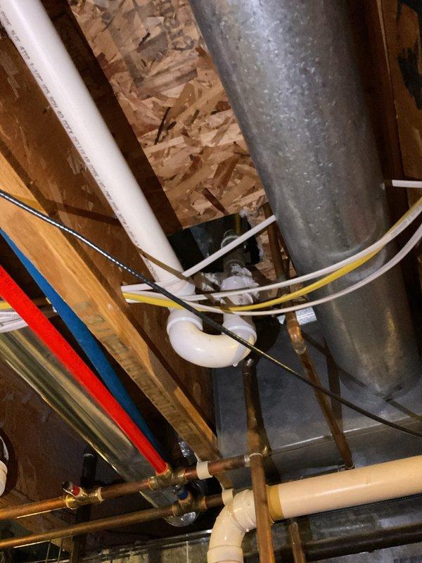 Responded to bathtub drain issue where the drain shoe elbow was broken following homeowner's attempt to replace overflow gasket. Upon inspection, assessed the existing brass waste and overflow assembly and discussed material options with customer, explaining the benefits and drawbacks of brass versus PVC systems. Brass offers superior durability and longevity but at higher material cost, while PVC provides adequate performance with easier installation and lower price point. Determined that full waste and overflow kit replacement was necessary due to compromised solder connection at drain shoe elbow that could not be reliably repaired. Documented existing plumbing configuration and mechanical systems in utility space for reference during replacement work.