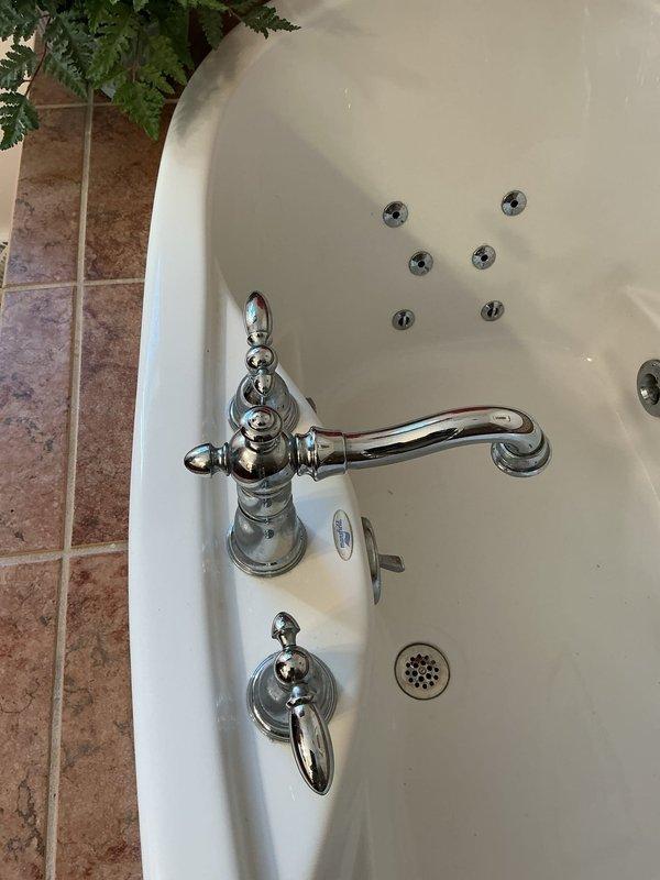 Completed bathroom faucet repair service for member with active monthly plan. Serviced chrome fixtures on both the bathtub's traditional-style single-handle faucet with diverter and the bathroom sink's three-piece faucet assembly with dual lever handles, ensuring proper operation and resolving reported plumbing issues.