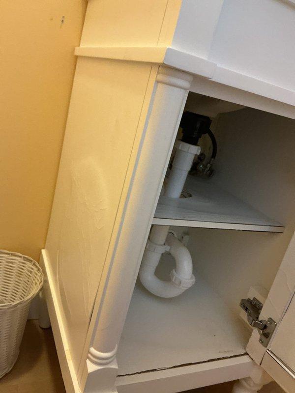 Responded to plumbing leak at vanity cabinet previously installed by company. Upon inspection, identified active leak at supply connections beneath sink. Client reported ongoing dissatisfaction with prior installation work, including damaged vanity cabinet showing mold deterioration requiring future replacement, but requested immediate focus on stopping the leak rather than full vanity removal at this time. Accessed cabinet interior, inspected P-trap assembly, supply lines, and shut-off valve connections. Tightened loose fittings and addressed source of water infiltration to stop active leak. Documented cabinet condition with photos showing plumbing configuration and cabinet interior. Leak successfully stopped as temporary measure until client decides on complete vanity replacement to address underlying mold and structural damage.