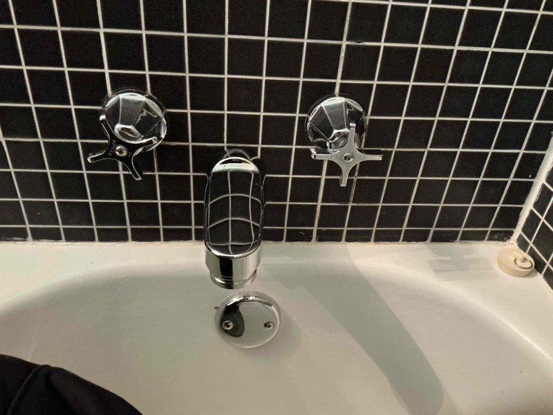 Completed comprehensive plumbing assessment of two bathroom areas with focus on shower and bathtub installations. Evaluated chrome fixtures including tub spout, dual-handle controls, drain assembly, and sink faucet for proper function and structural support. Documented existing conditions with photos showing bathtub plumbing against black tile wall and sink faucet installation. Assessed need for additional strapping or support work to address issues beyond standard leak repair, providing recommendations for overall plumbing system improvements in both bathroom locations.
