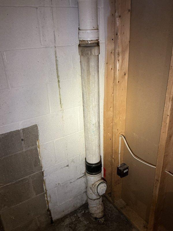 Responded to washer drain backup issue. Upon inspection, found existing PVC drain line showing signs of age and deterioration with visible soiling along vertical run. Cleared obstruction from drain line and verified proper flow restoration. Tested system operation to ensure washer drainage functioning correctly without backup. System operational upon completion.