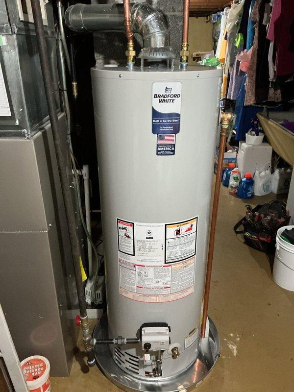 Completed installation of a 40-gallon Bradford White natural gas water heater (Model RG2PV) with natural draft venting in basement utility area. Unit was properly connected to existing copper supply lines, gas line, and venting system, with overflow pan positioned at base per code requirements. All manufacturer specifications were verified, including 40,000 BTU/hr input rating and proper gas pressure settings, and unit was tested for safe operation upon completion.