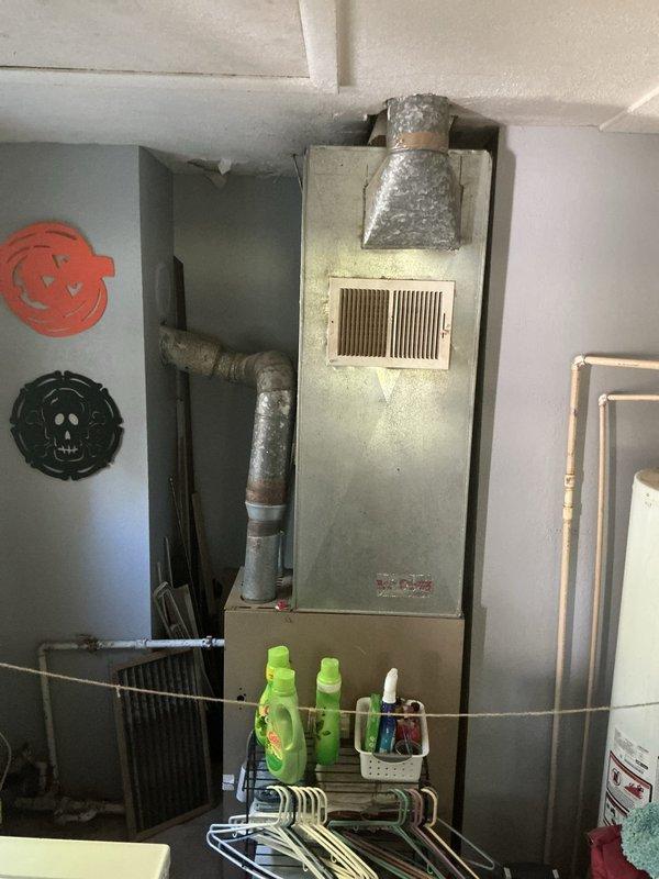 Completed furnace replacement estimate for approximately 1200 square foot residence with 60-year-old unit experiencing blower motor failure and wall pin deterioration. Photographed existing HVAC system showing internal components including failed blower assembly, gas burner system, electrical controls, and overall cabinet condition to document equipment age and failure points. Provided estimate information within expedited timeline to meet DHS requirements for heating system replacement approval.
