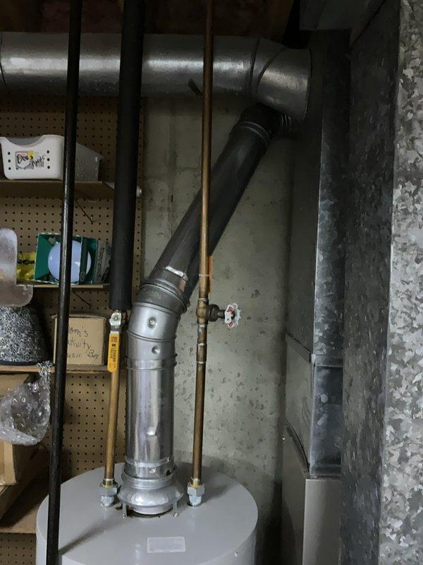 Responded to no hot water call for 17-year-old Bradford water heater. Upon inspection, documented existing venting system configuration with metallic vent pipe assembly and copper supply lines with brass fittings. Unit age and condition assessed; customer advised of operational status and system evaluation completed per standard protocols.