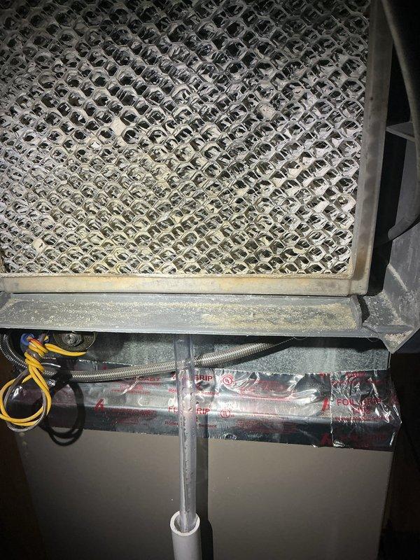 Responded to report of water leaking from furnace while unit continued to operate. Upon inspection, identified condensate drainage issue affecting the HVAC system. Examined the furnace evaporator coil assembly and associated condensate removal components, including the PVC drainage piping secured to the basement wall. Inspected the heating elements, blower assembly, and ductwork connections for signs of moisture intrusion. Assessed the condensate drain line routing and verified proper pitch and connection points. Cleared any blockages in the drainage system and confirmed proper condensate flow. Tested furnace operation to ensure heating functionality remained intact while resolving the water leak condition. Unit restored to normal operation with no further water discharge observed.