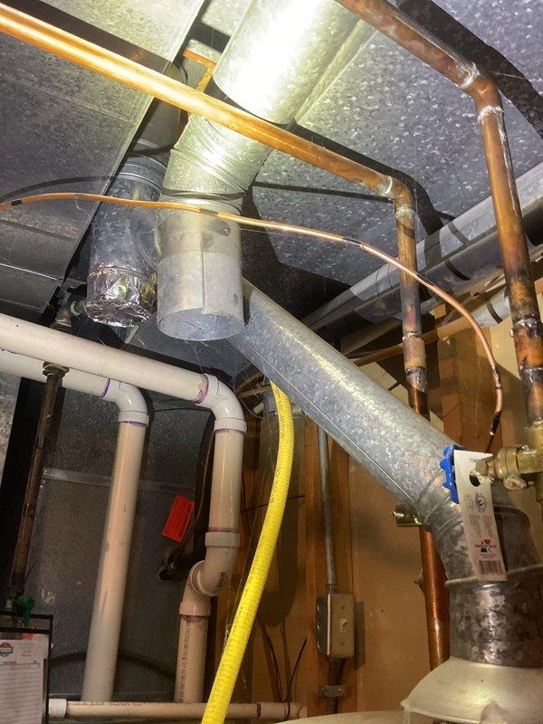 Completed water heater tune-up on residential gas-fired unit located in basement utility area. Performed standard maintenance inspection of all connections, verified proper operation of temperature and pressure relief valve, checked gas line connections and copper supply piping, and confirmed adequate venting and ductwork clearances throughout the mechanical system.
