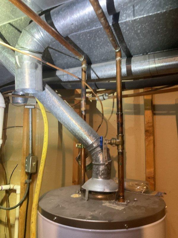 Completed water heater tune-up on residential gas-fired unit located in basement utility area. Performed standard maintenance inspection of all connections, verified proper operation of temperature and pressure relief valve, checked gas line connections and copper supply piping, and confirmed adequate venting and ductwork clearances throughout the mechanical system.