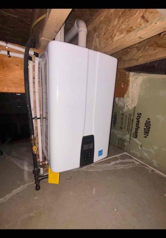 Responded to service call for tankless water heater with reported loose piping and PCB connection issues in basement installation. Upon arrival, inspected white Energy Star-rated tankless unit mounted on concrete wall with PVC venting, copper water lines, and flexible gas piping. Secured disconnected pipe connection and reseated PCB board in control panel to restore proper electrical contact. Verified all gas line connections, water supply lines, and exhaust venting were properly secured and sealed. Tested unit operation and confirmed proper ignition, flame sensing, and hot water delivery throughout system. All connections tightened to manufacturer specifications and unit returned to normal operating condition.