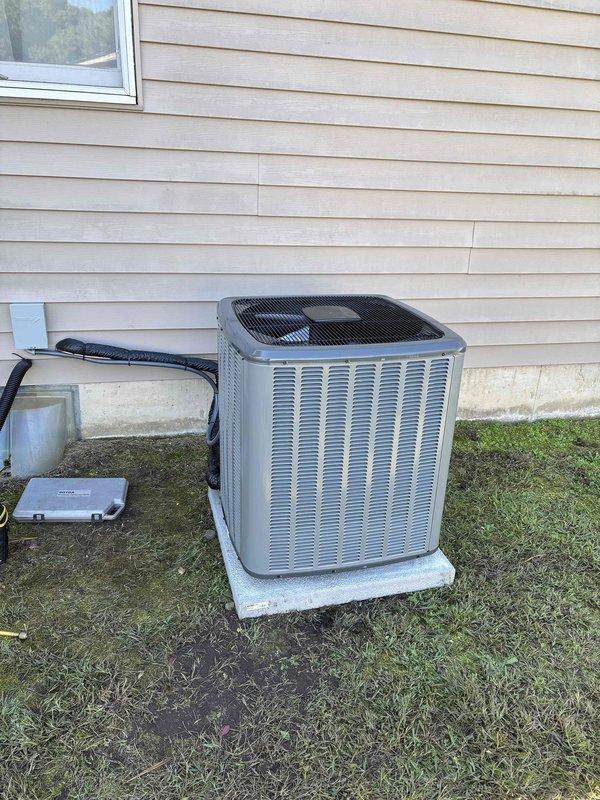 Completed full HVAC system installation including new furnace and air conditioning condenser unit. Installed furnace in basement mechanical room on protective mat with proper clearances, connected white PVC exhaust and intake venting routed vertically through structure, and integrated white humidifier unit to left side of furnace cabinet. Ran copper refrigerant lines from furnace to exterior, secured with mounting brackets. Installed outdoor AC condenser unit on level concrete pad in backyard, connected refrigerant lines and electrical disconnect box mounted to exterior wall. Configured metallic supply ductwork from furnace plenum, routed through ceiling joists. Verified all electrical connections, tested system operation, confirmed proper airflow and refrigerant charge levels, and ensured all safety controls functioning correctly.