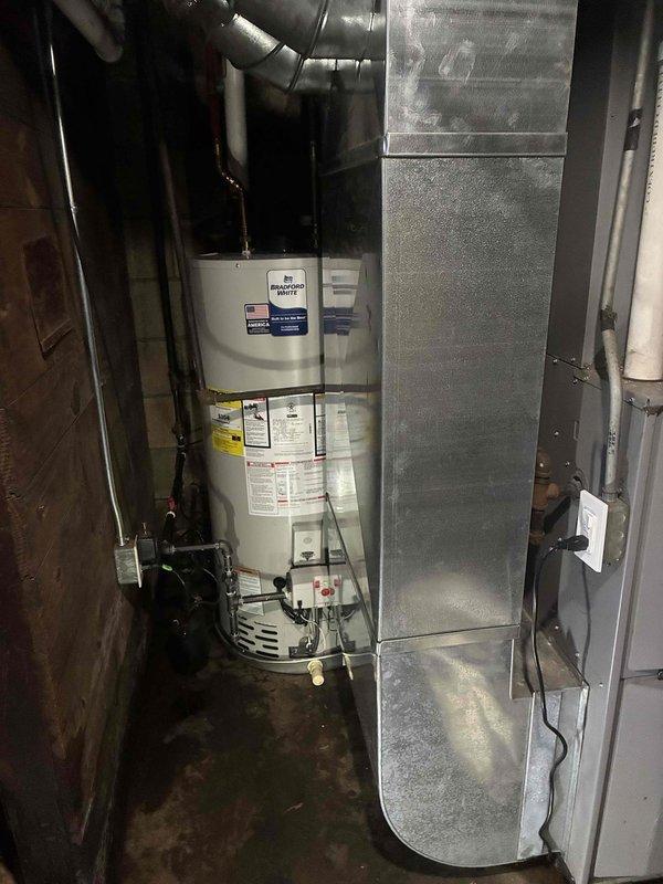 Completed full installation of Bradford White automatic storage water heater in mechanical room, including all necessary gas piping connections, water supply lines, and proper venting. Replaced existing condensate pump to ensure proper drainage from HVAC system. All equipment tested and verified operational per manufacturer specifications, with safety labels and operating instructions clearly visible on installed unit.
