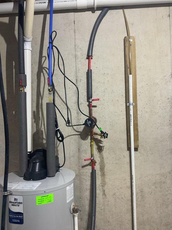 Responded to emergency water leak at pump assembly near Bradford White water heater, representing third failure of this component. Upon arrival, assisted homeowner in locating water shutoff since main valve could not be identified, coordinating with water utility to shut off supply at street to stop major leak and prevent further property damage. Inspected water heater plumbing connections, PEX supply lines, and pump assembly to identify failure point and stabilize system.