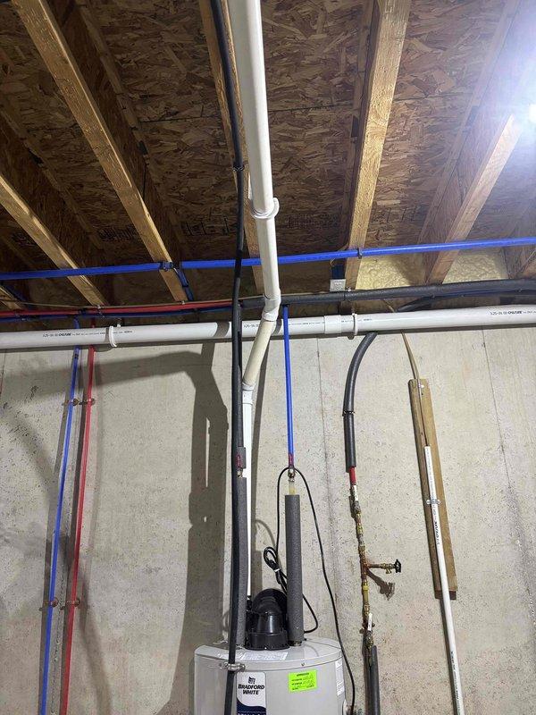 Responded to emergency water leak at pump assembly near Bradford White water heater, representing third failure of this component. Upon arrival, assisted homeowner in locating water shutoff since main valve could not be identified, coordinating with water utility to shut off supply at street to stop major leak and prevent further property damage. Inspected water heater plumbing connections, PEX supply lines, and pump assembly to identify failure point and stabilize system.