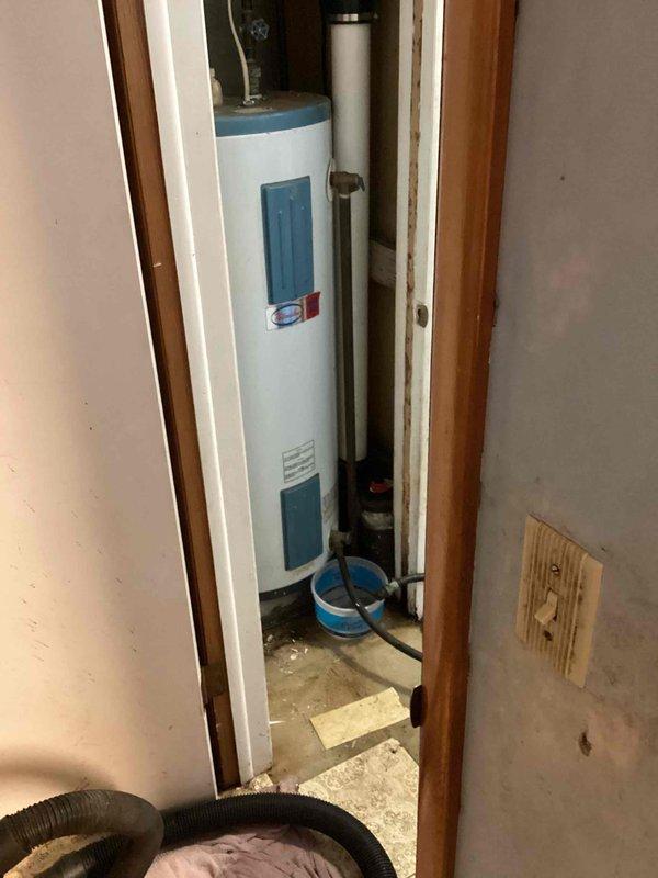 Completed water heater replacement estimate for residential single-family home with 30-year-old tank-style unit showing signs of moisture damage and water staining on floor and surrounding walls. Documented existing equipment specifications, plumbing connections including copper piping and brass fittings, venting configuration, and installation space constraints within utility closet. Provided replacement options and recommendations for new water heater installation.