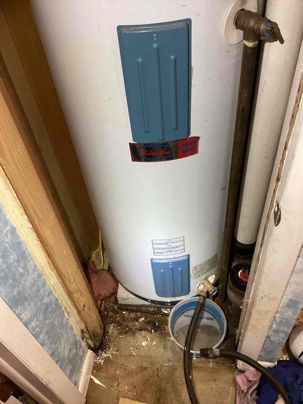 Completed water heater replacement estimate for residential single-family home with 30-year-old tank-style unit showing signs of moisture damage and water staining on floor and surrounding walls. Documented existing equipment specifications, plumbing connections including copper piping and brass fittings, venting configuration, and installation space constraints within utility closet. Provided replacement options and recommendations for new water heater installation.