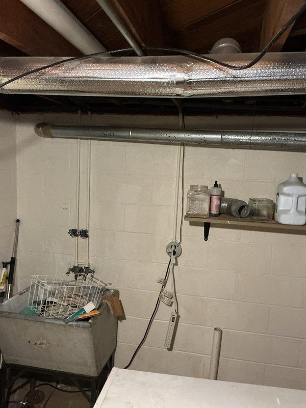 Provided estimate for replacement of 20+ year old standard tank water heater presenting active leak in basement utility area. Unit assessed as end-of-service-life with minor but ongoing water seepage, requiring full replacement rather than repair. Documented existing installation conditions and photographed equipment location for replacement planning.
