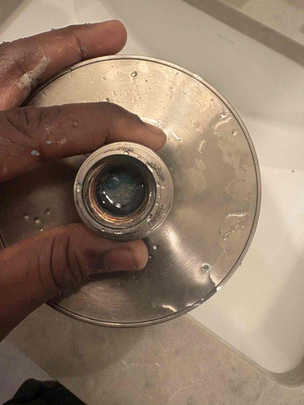 Responded to no water complaint at residential property with history of water heater issues. Upon inspection, discovered severely clogged faucet aerators throughout home causing reduced water flow that appeared as complete water loss. Removed and examined shower trim valve and multiple faucet aerators, finding significant mineral buildup and sediment deposits restricting water passage. Cleaned aerator screens showing blue-green corrosion and mineral accumulation. Restored water flow to affected fixtures by clearing blockages and reinstalling components.