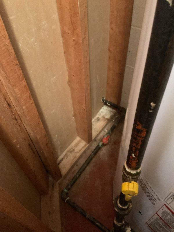 Completed on-site evaluation for tankless water heater replacement estimate at single-family residence. Assessed existing water heater installation in basement, documented current gas meter configuration showing significant corrosion on inlet/outlet connections and upper piping, and evaluated utility infrastructure including pressure regulator and gas supply lines. Photographed basement plumbing configuration with exposed framing, existing water supply pipes, and shut-off valves to determine feasibility and requirements for tankless conversion installation.
