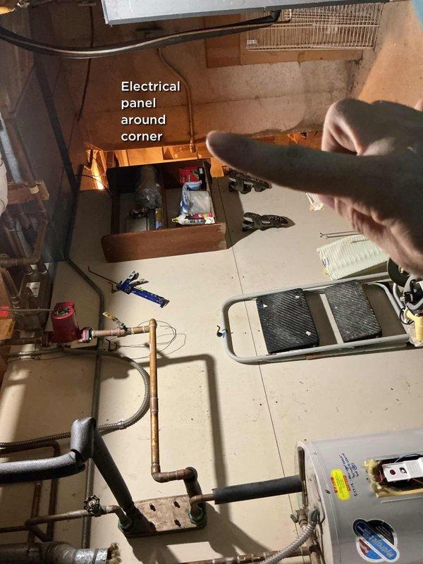 Responded to no hot water call for tank-type water heater in basement utility area. Upon arrival, found unit to be approximately 15+ years old, predating customer's 2012 occupancy. Performed diagnostic inspection of water heater and associated plumbing connections, including examination of gas supply lines, water inlet/outlet piping, temperature and pressure relief valve, and electrical components. Noted this unit differs from the Bradford White model previously on file in system records. Documented equipment condition and configuration with photographs showing copper supply piping, black insulated lines, and overall installation layout. Verified electrical panel location around corner from water heater for reference. Unit assessed as aged beyond typical service life expectancy for residential tank water heaters.