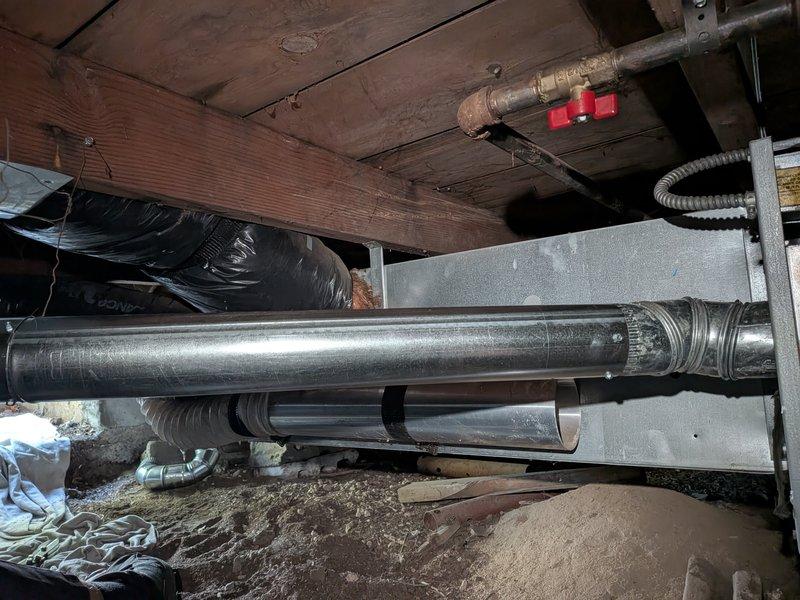 Completed gas valve and exhaust venting repair in crawl space area. Accessed underfloor mechanical systems, inspected HVAC ductwork and gas line components, replaced faulty gas valve assembly with red shutoff valve visible on copper gas line, and verified proper exhaust venting connections to ensure safe operation and code compliance.
