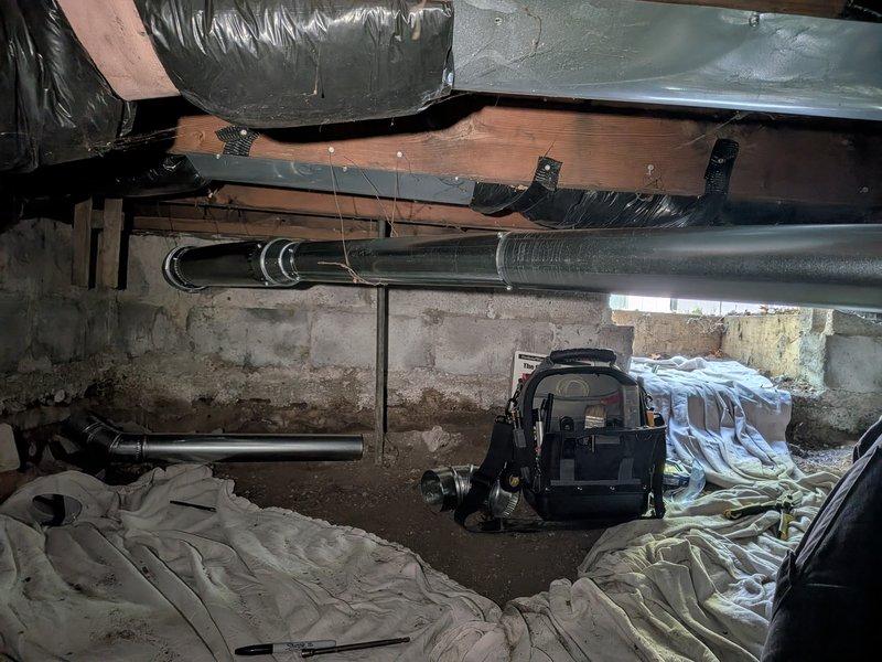 Completed gas valve and exhaust venting repair in crawl space area. Accessed underfloor mechanical systems, inspected HVAC ductwork and gas line components, replaced faulty gas valve assembly with red shutoff valve visible on copper gas line, and verified proper exhaust venting connections to ensure safe operation and code compliance.
