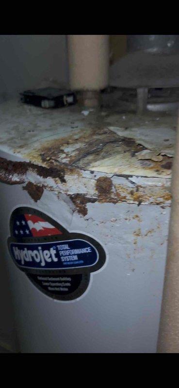 Completed annual heating maintenance and furnace tune-up on approximately 2-year-old system. Unit exhibited significant age-related wear with dust accumulation, interior discoloration, and oxidation on metal components. HydroJet water system showed extensive deterioration with peeling exterior coating and rust damage on top surface, along with visible moisture staining on surrounding floor area.