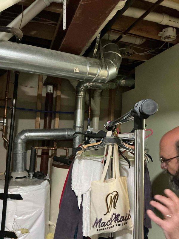 Provided updated water heater replacement estimate for existing unit located in mechanical room. Assessed current 2016 water heater installation, surrounding plumbing connections, ductwork configuration, and available workspace for replacement equipment. Documented existing conditions with photographs showing unit positioning, piping layout, and clearance requirements for future installation work.