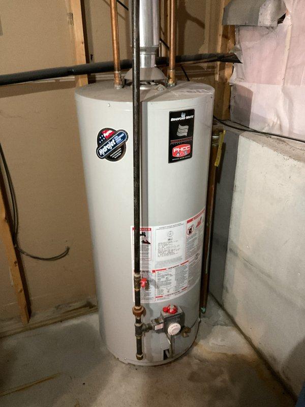 Responded to service call for water heater replacement estimate. Customer reported that their existing 40-gallon short water heater was causing basement flooding when running water. Conducted on-site inspection and photographed the existing Bradford White water heater installation in the basement utility area. Evaluated current unit's condition, plumbing connections including copper supply lines, brass fittings with red-handled valves, pressure relief components, and metal flue ventilation system. Assessed surrounding basement infrastructure including exposed wall framing, concrete flooring, and available clearances for replacement unit installation. Provided comprehensive estimate for replacing the failing 40-gallon short water heater with appropriate new unit to resolve flooding issue.