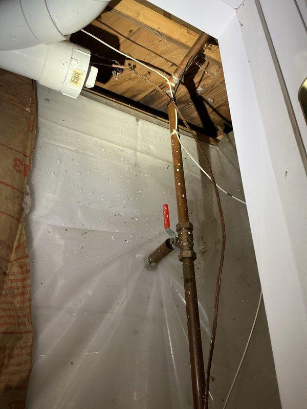 Conducted comprehensive site assessment for exterior spigot installation. Evaluated existing plumbing infrastructure including interior copper supply lines with shutoff valve access through ceiling cavity and exterior drainage system along foundation. Documented current pipe routing, identified optimal connection points for new hose bib installation, and assessed structural considerations for wall penetration through concrete block exterior. Photographed interior water supply configuration and exterior mounting location near landscaped drainage area to develop accurate material list and installation plan for customer approval.