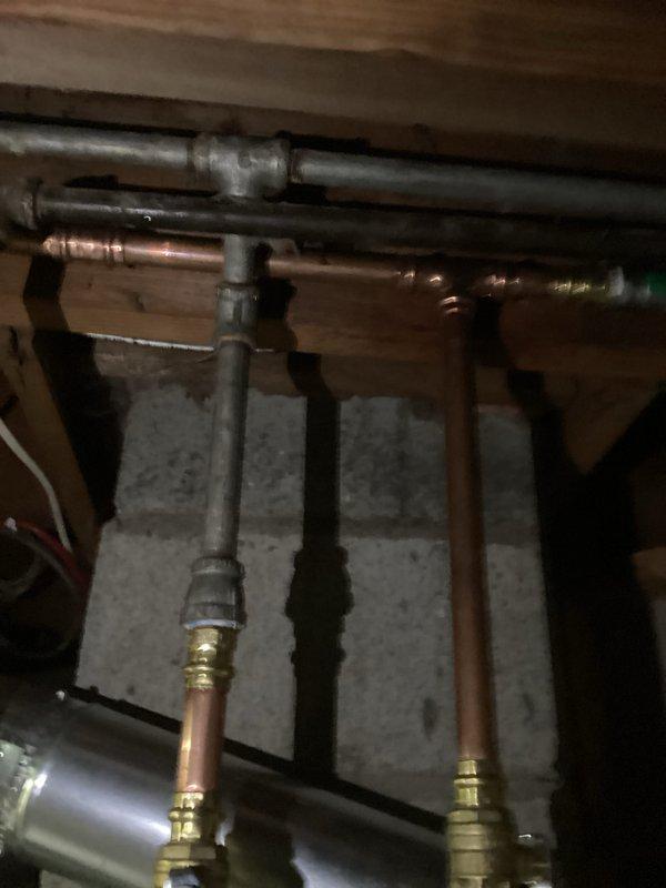 Successfully installed a 40-gallon natural draft natural gas water heater (short tank model, 48 1/16" height) in basement utility area. Connected all copper supply lines with brass fittings and unions, installed PVC venting system, and integrated unit with existing plumbing infrastructure including gas line connections. Installation includes 6-year parts and 1-year labor warranty coverage.