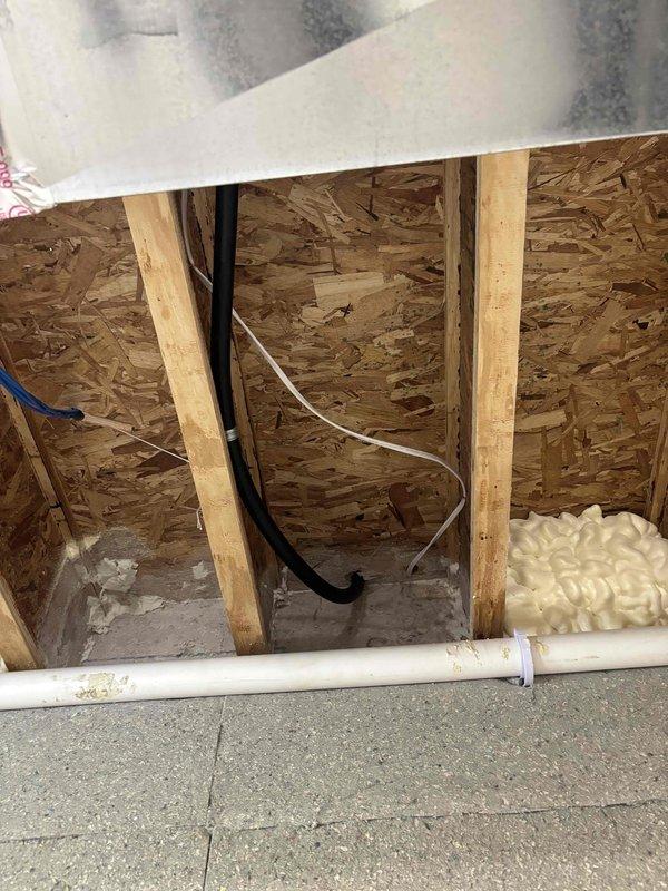 Successfully installed a new unit heater system in the attic space. Installation included mounting the unit heater between floor joists, running electrical wiring (black and white conductors) through the wall cavity to power the unit, and connecting necessary ductwork with flexible ducting routed through the attic structure. Applied spray foam insulation at penetration points to seal gaps and prevent air leakage around the installation area. All work completed to manufacturer specifications with proper electrical connections and structural support utilizing existing roof trusses and floor joists.