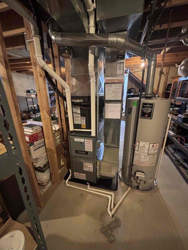 Completed full HVAC system installation including new furnace and air conditioning condenser unit. Installed furnace in basement mechanical room with proper clearances and ventilation requirements, connected silver ductwork to existing distribution system, and integrated with PVC drainage piping. Mounted outdoor AC condenser unit on concrete pad against exterior wall with protective top grille, verified proper refrigerant line connections between indoor and outdoor components. All equipment labeled with manufacturer specifications, system tested for proper operation, and installation meets code requirements for residential heating and cooling applications.