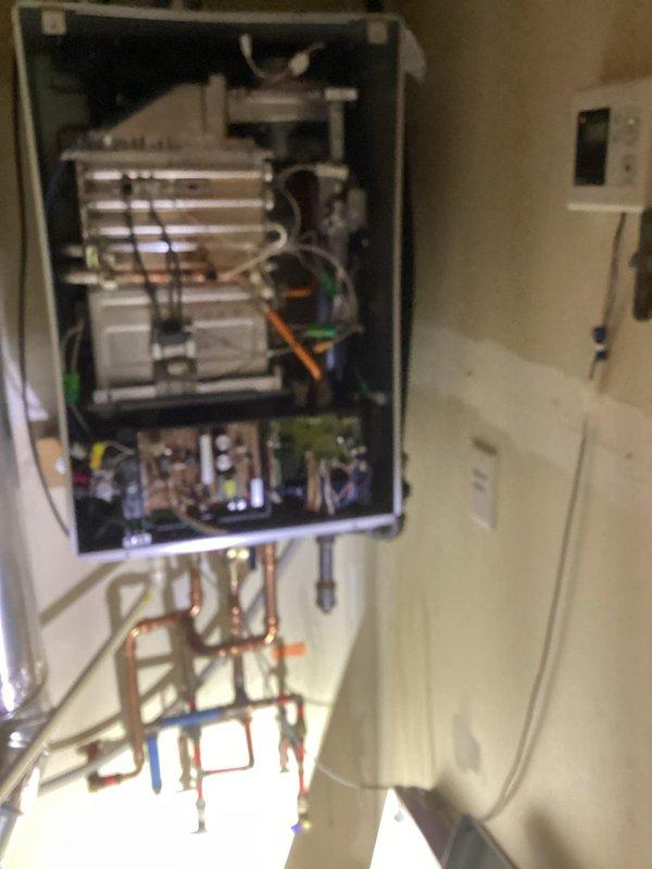 Responded to service call for dual Noritz tankless water heater system with reported slow hot water delivery. Performed diagnostic inspection of both units, accessing internal components to assess heat exchanger condition, control boards, and plumbing configuration. Evaluated digital controller display showing operational status and reviewed system settings. Inspected copper supply and return piping, connection points, and isolation valves for proper installation and flow restrictions. Photographed equipment configuration and internal components for documentation. Provided customer with diagnostic findings and quoted necessary repairs to restore optimal hot water delivery performance.