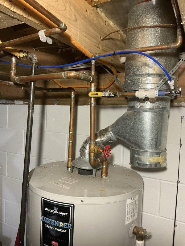 Provided estimate for replacement of existing Bradford White water heater in residential basement mechanical room. Assessed current installation including copper supply lines, galvanized ductwork connections, expansion tank with blue flexible connector, and associated plumbing components with brass fittings and shutoff valves. Documented existing configuration and presented replacement options to customer.