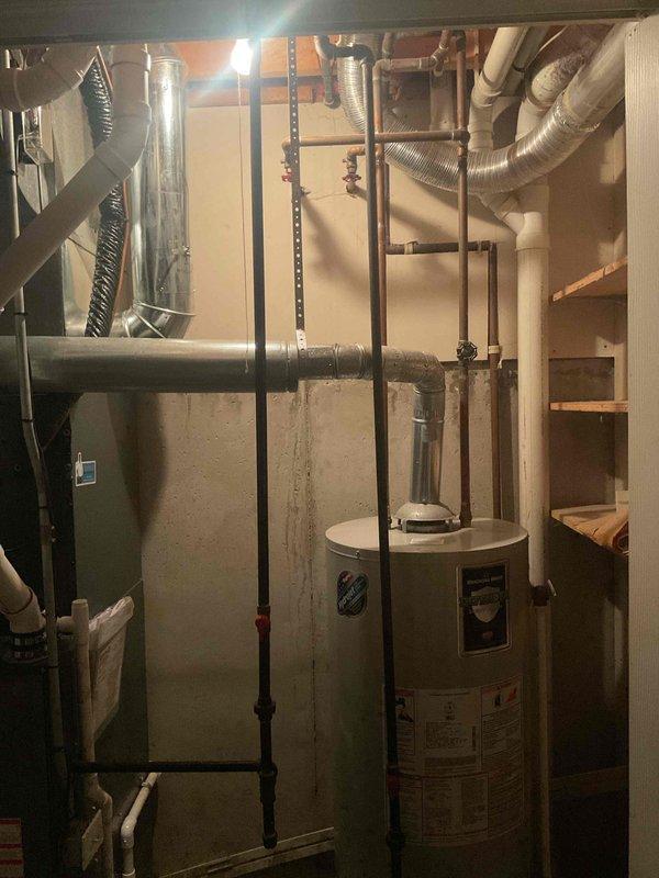 Conducted water heater replacement estimate for residential property with existing conventional tank-style water heater located in basement utility room. Evaluated current installation including venting configuration, gas line connections, and plumbing infrastructure. Provided comprehensive estimate options for both tankless water heater system and traditional tank-style replacement units per client request, discussing advantages and considerations of each system type based on household needs and existing mechanical setup.