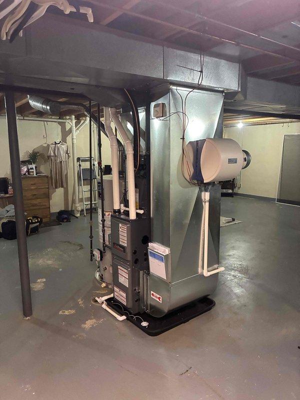 Completed full HVAC system installation in residential basement including new furnace and air conditioning unit. Installed complete system with integrated humidifier, proper ductwork connections, condensate drain pan, and all necessary electrical and gas connections. System tested and verified operational with all components functioning correctly, replacement air filter provided to homeowner.