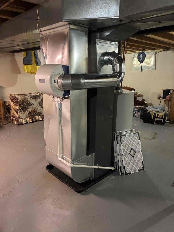 Completed full HVAC system installation in residential basement including new furnace and air conditioning unit. Installed complete system with integrated humidifier, proper ductwork connections, condensate drain pan, and all necessary electrical and gas connections. System tested and verified operational with all components functioning correctly, replacement air filter provided to homeowner.