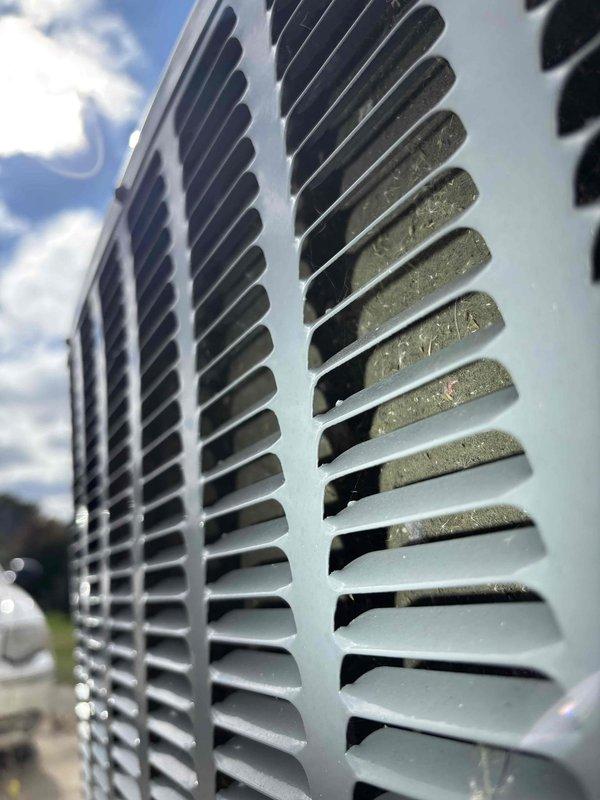 Responded to service call for non-operational air conditioning unit. Upon arrival, performed visual inspection of outdoor condensing unit and identified significant accumulation of dirt, dust, and debris on the exterior grille and louvered vents, which was restricting proper airflow to the system. Cleaned the protective grille thoroughly, removing buildup from horizontal slats and vent openings to restore adequate ventilation. Verified unit operation and confirmed system returned to normal cooling function after airflow obstruction was cleared.