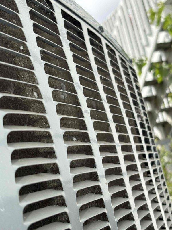 Responded to service call for non-operational air conditioning unit. Upon arrival, performed visual inspection of outdoor condensing unit and identified significant accumulation of dirt, dust, and debris on the exterior grille and louvered vents, which was restricting proper airflow to the system. Cleaned the protective grille thoroughly, removing buildup from horizontal slats and vent openings to restore adequate ventilation. Verified unit operation and confirmed system returned to normal cooling function after airflow obstruction was cleared.
