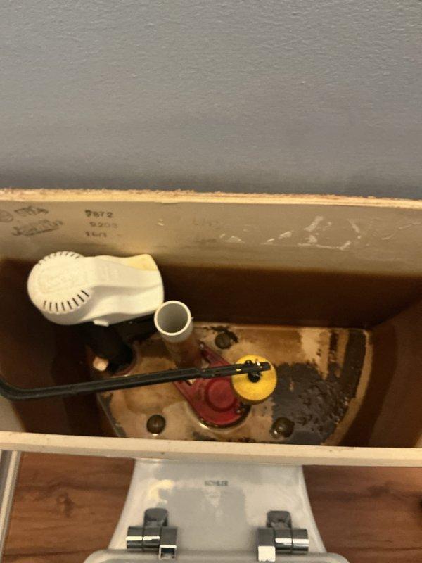 Responded to toilet repair request and performed inspection of tank components. Upon examination, found aging flush valve assembly with worn flapper and deteriorated seals, along with mineral buildup throughout tank interior. Replaced flush valve assembly including new flapper mechanism and seals to restore proper flushing function. Tested system for proper operation and verified no leaks present. Documented existing conditions with photos showing before-service state of internal components and mineral deposits.